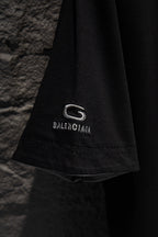 Balenciaga black T-shirt hem detail with G logo patch and BALENCIAGA text