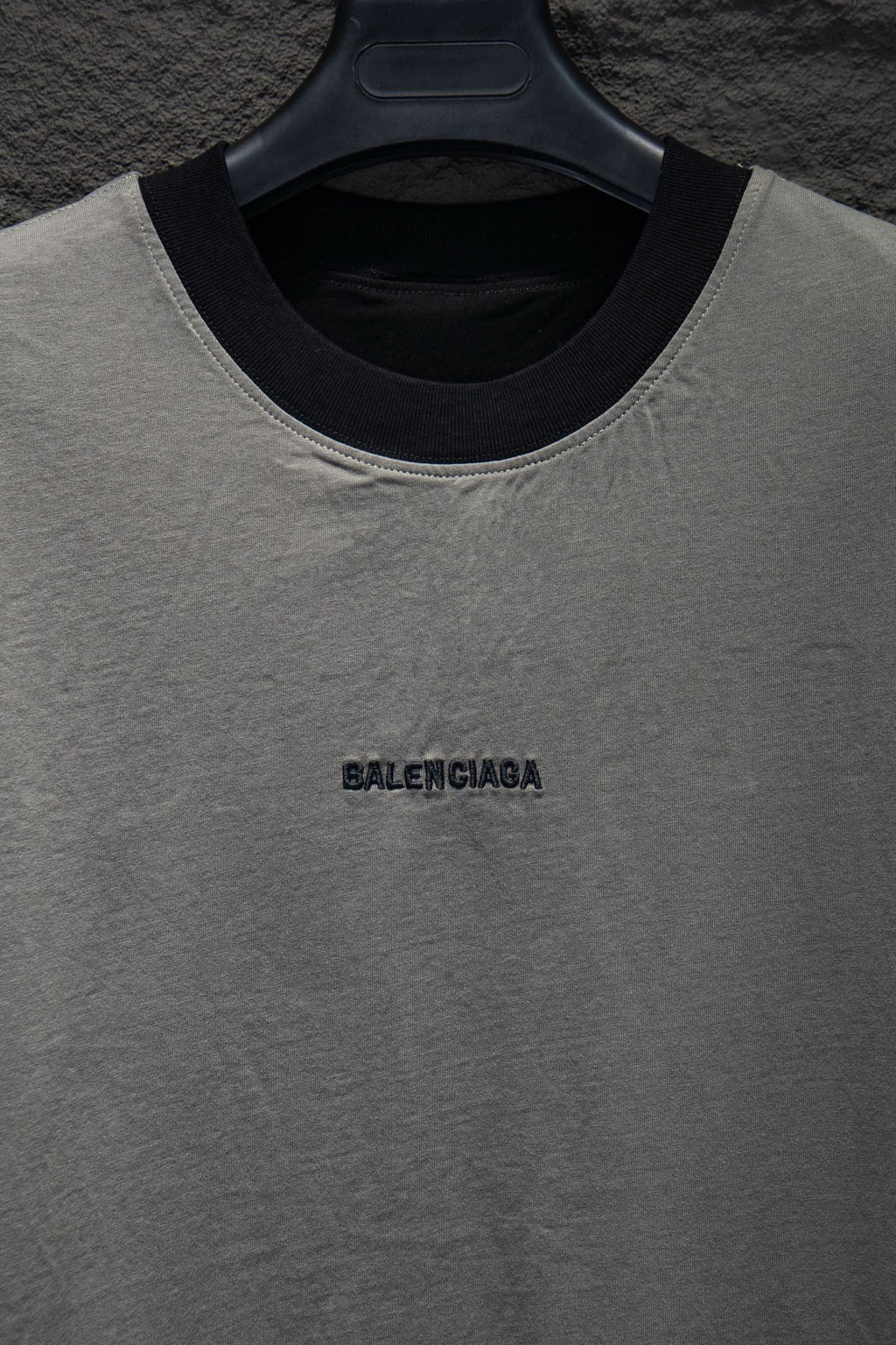 Balenciaga T-shirt neckline close-up, light gray with black collar trim and logo