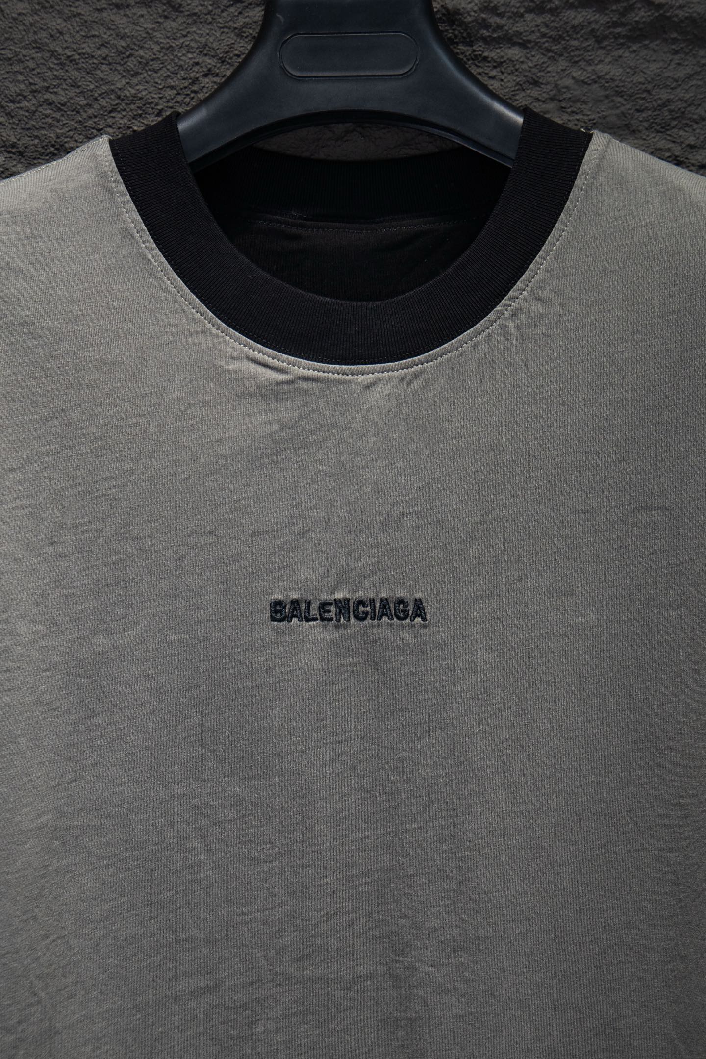 Balenciaga T-shirt neckline close-up, light gray with black collar trim and logo