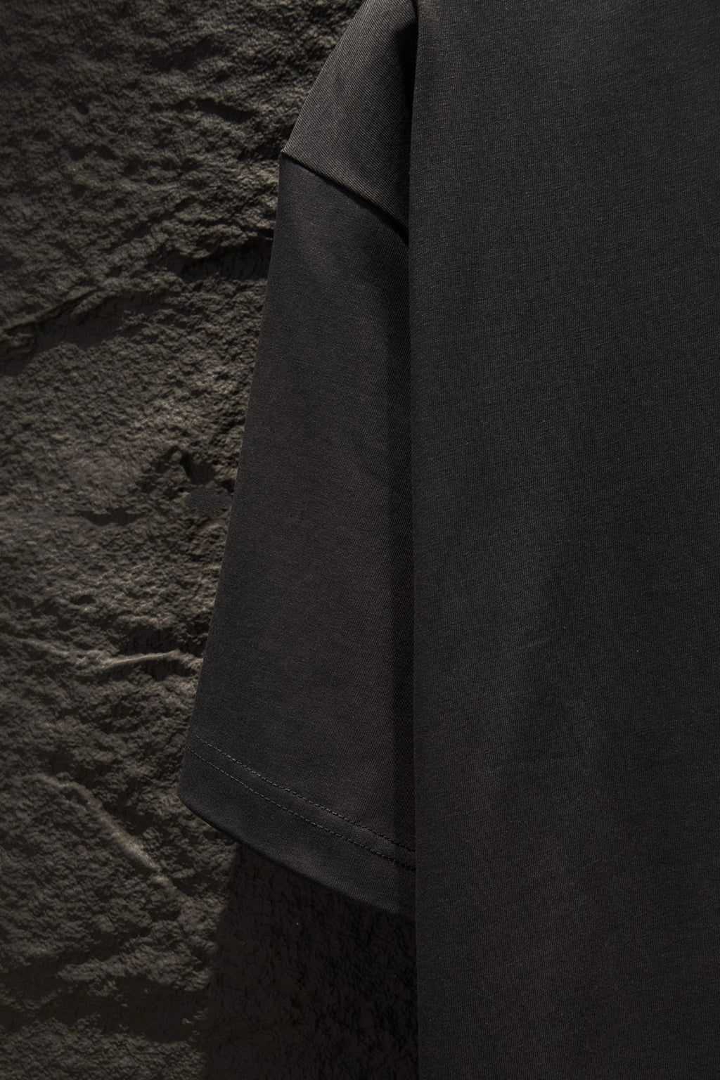 Black short-sleeve T-shirt side view showing drape and hem