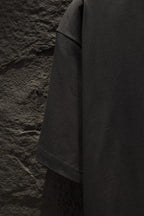 Black short-sleeve T-shirt side view showing drape and hem