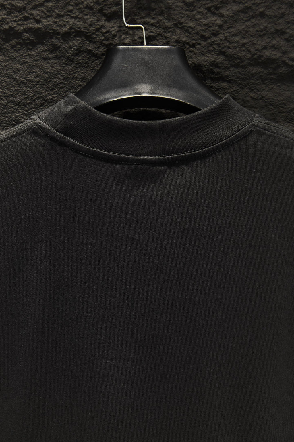 Black crewneck T-shirt collar on a hanger