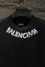 Black crewneck T-shirt with large white BALENCIAGA logo across chest.