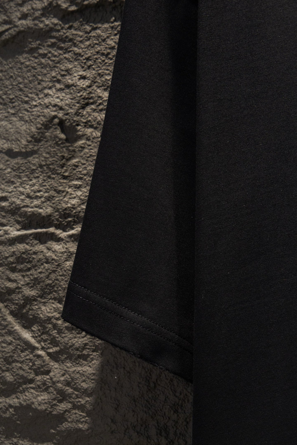 Black short-sleeve T-shirt side view with straight hem.