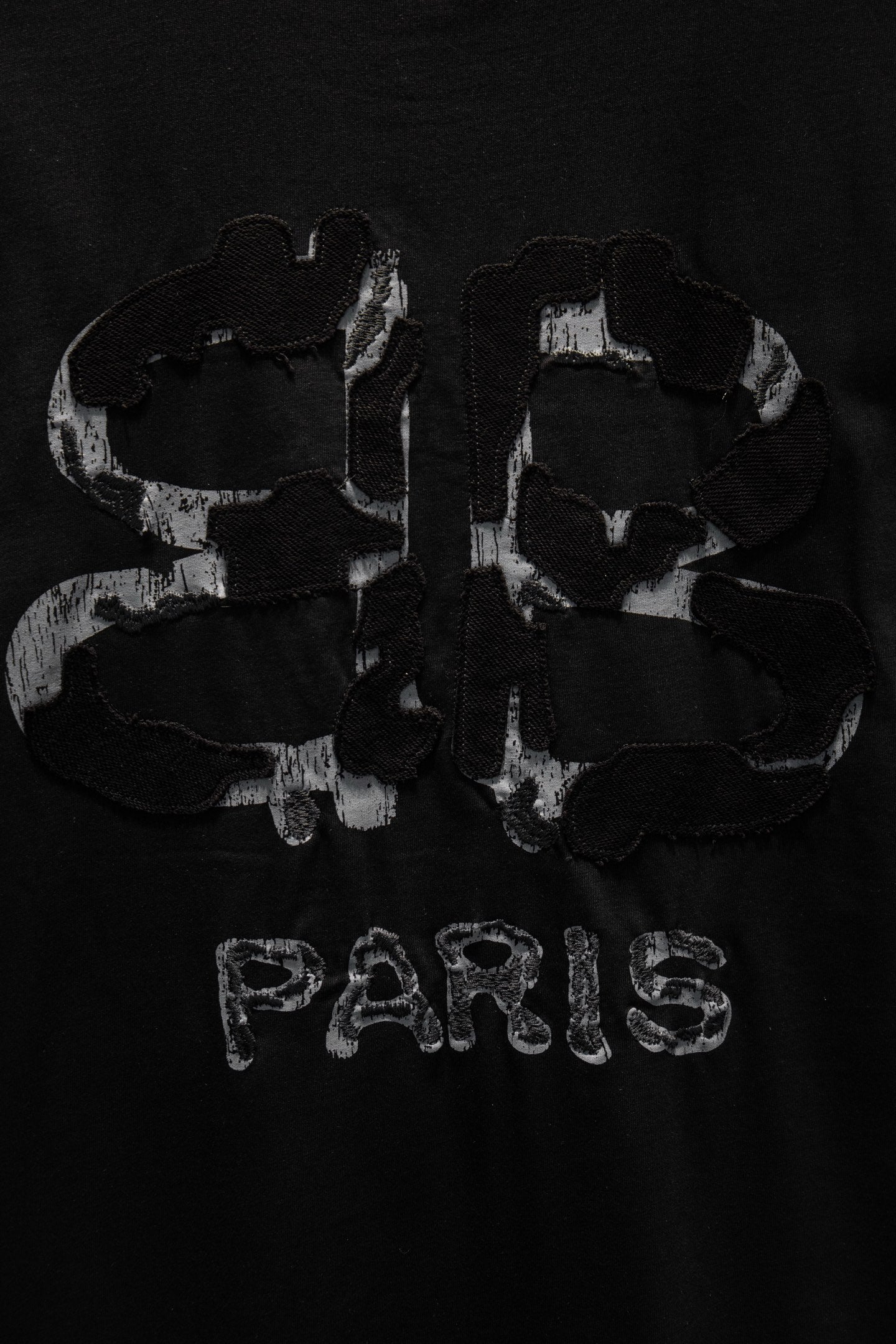 Black short-sleeve T-shirt with PARIS text and abstract back graphic.