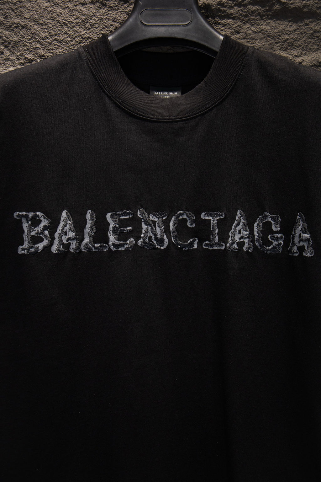 Black short-sleeve T-shirt with BALENCIAGA graphic lettering at chest.