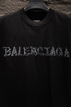 Black short-sleeve T-shirt with BALENCIAGA graphic lettering at chest.