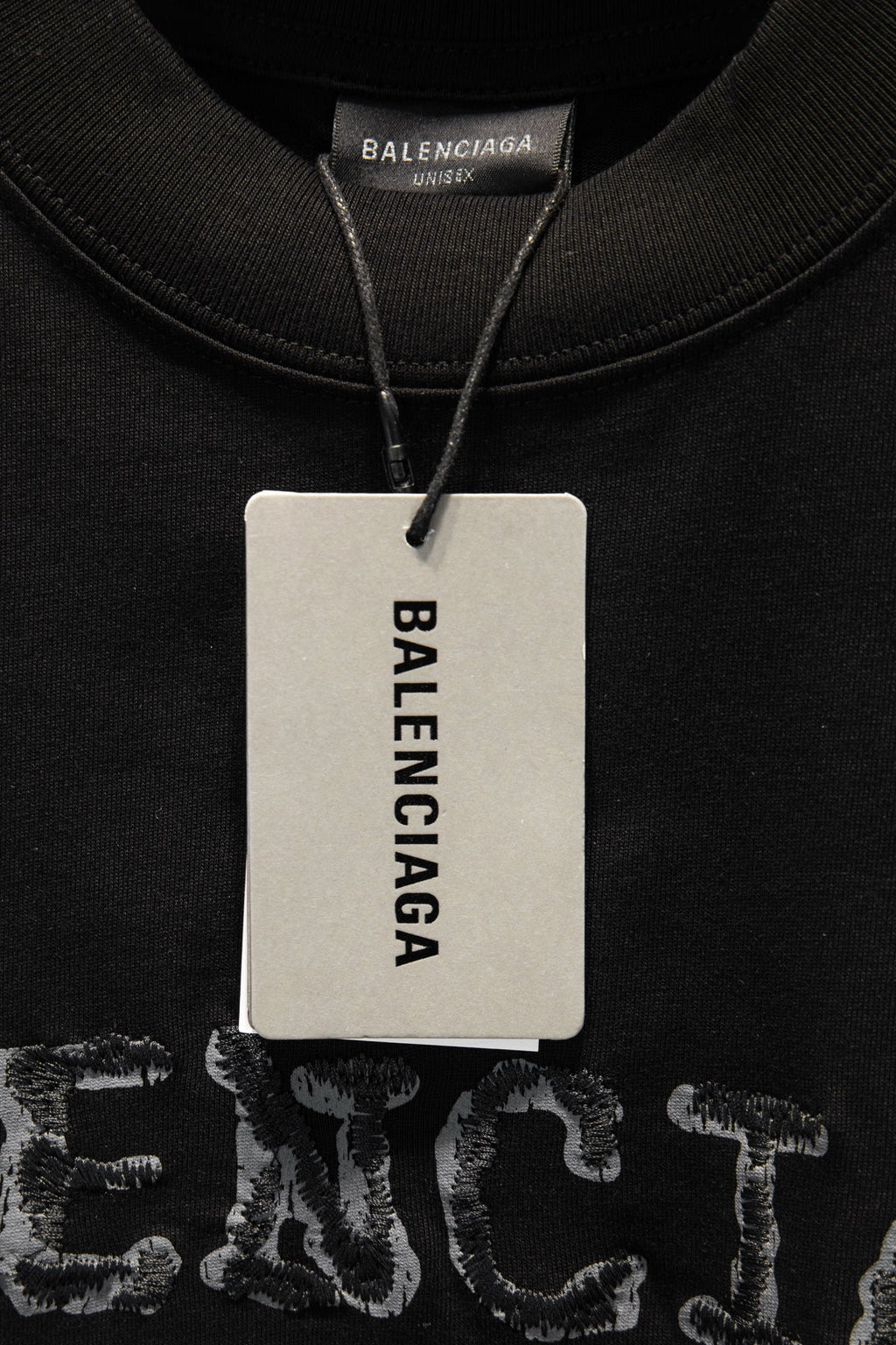 Black short-sleeve T-shirt with BALENCIAGA neck hang tag.