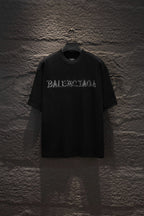 Black short-sleeve T-shirt with BALENCIAGA chest graphic.