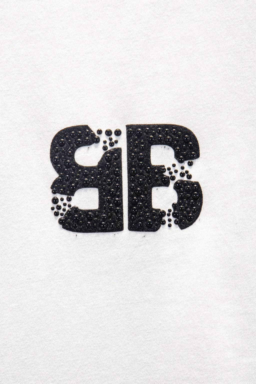 Balenciaga front logo patch on white T-shirt, black glitter-style print