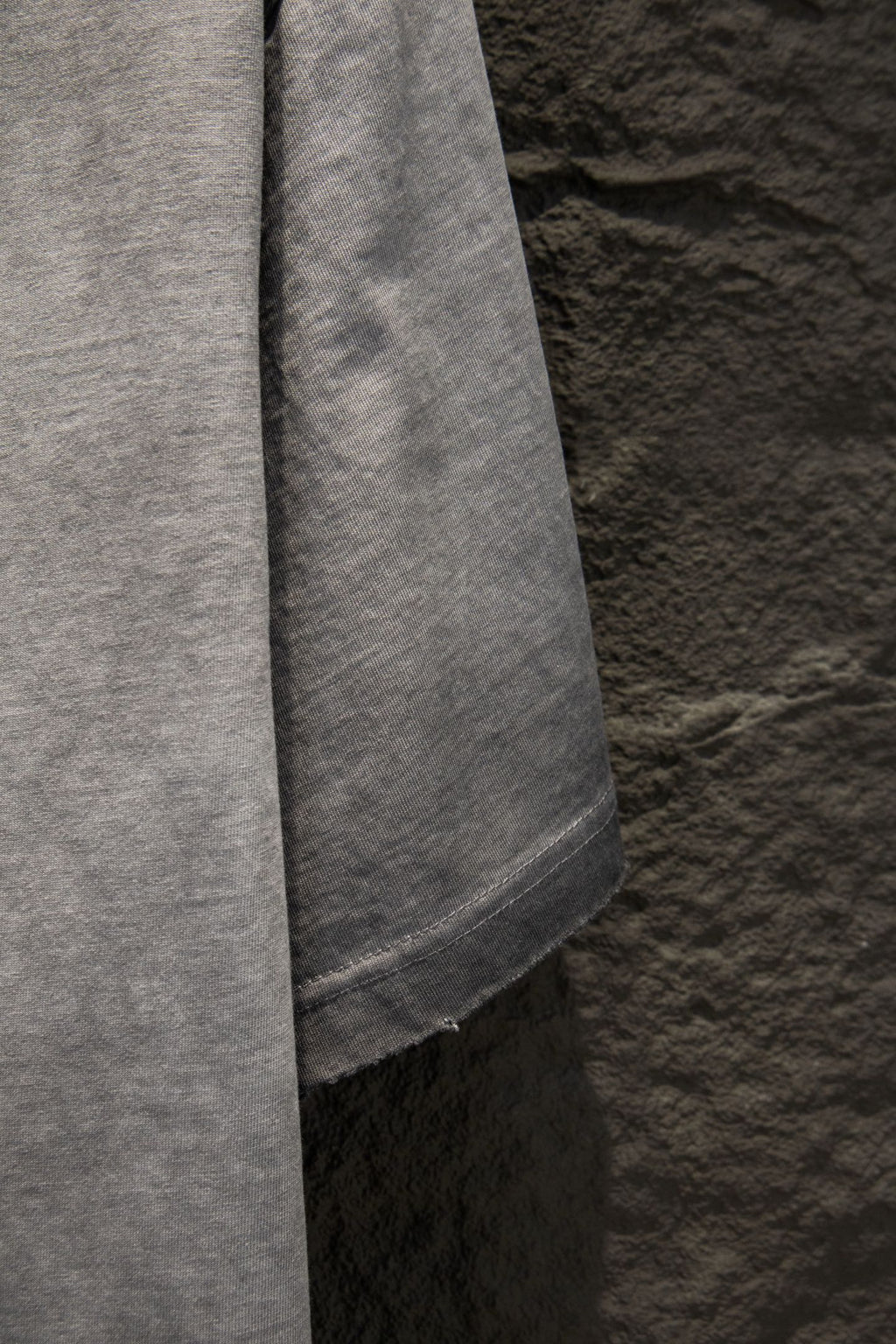 Light gray T-shirt side seam and curved lower hem