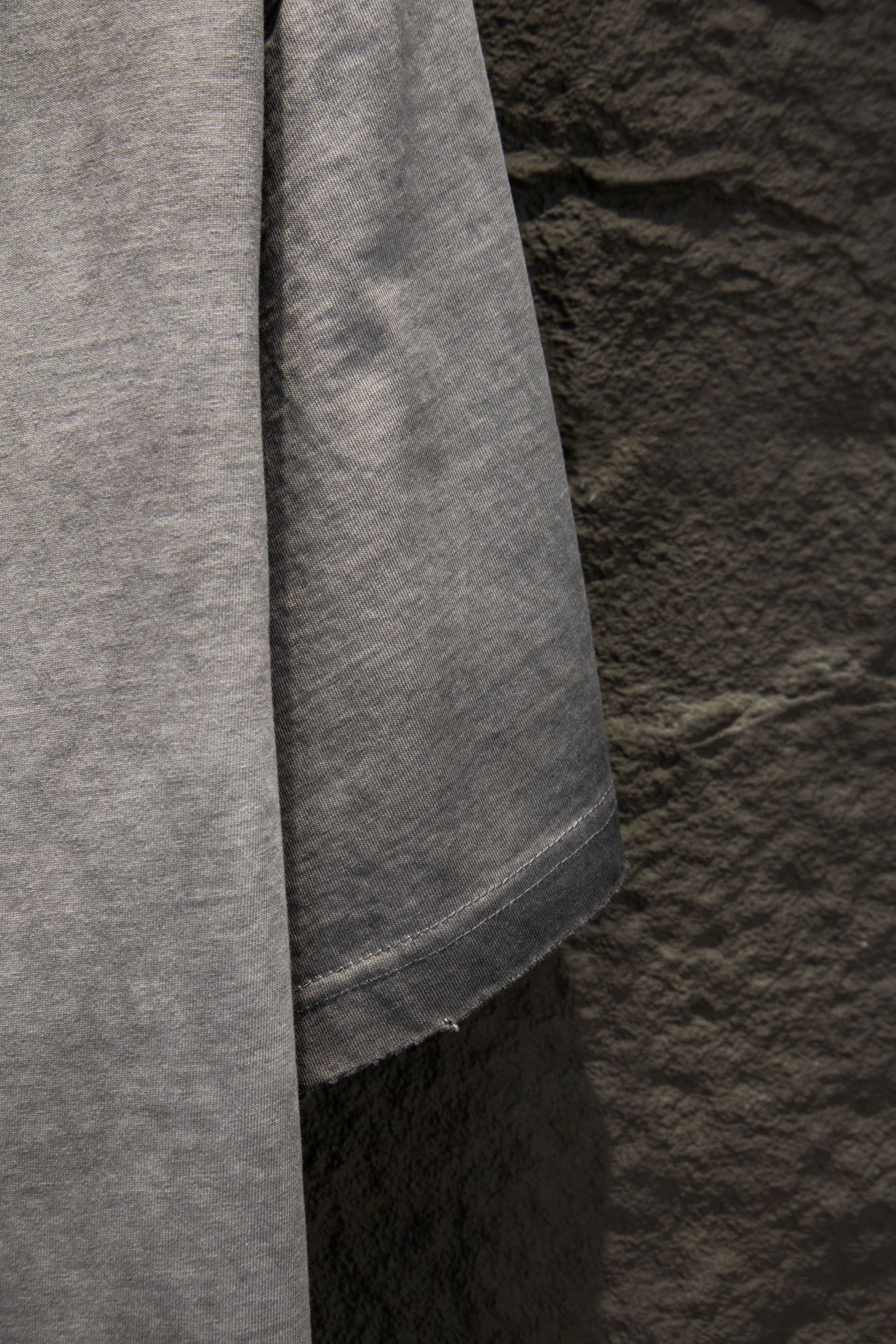 Light gray T-shirt side seam and curved lower hem