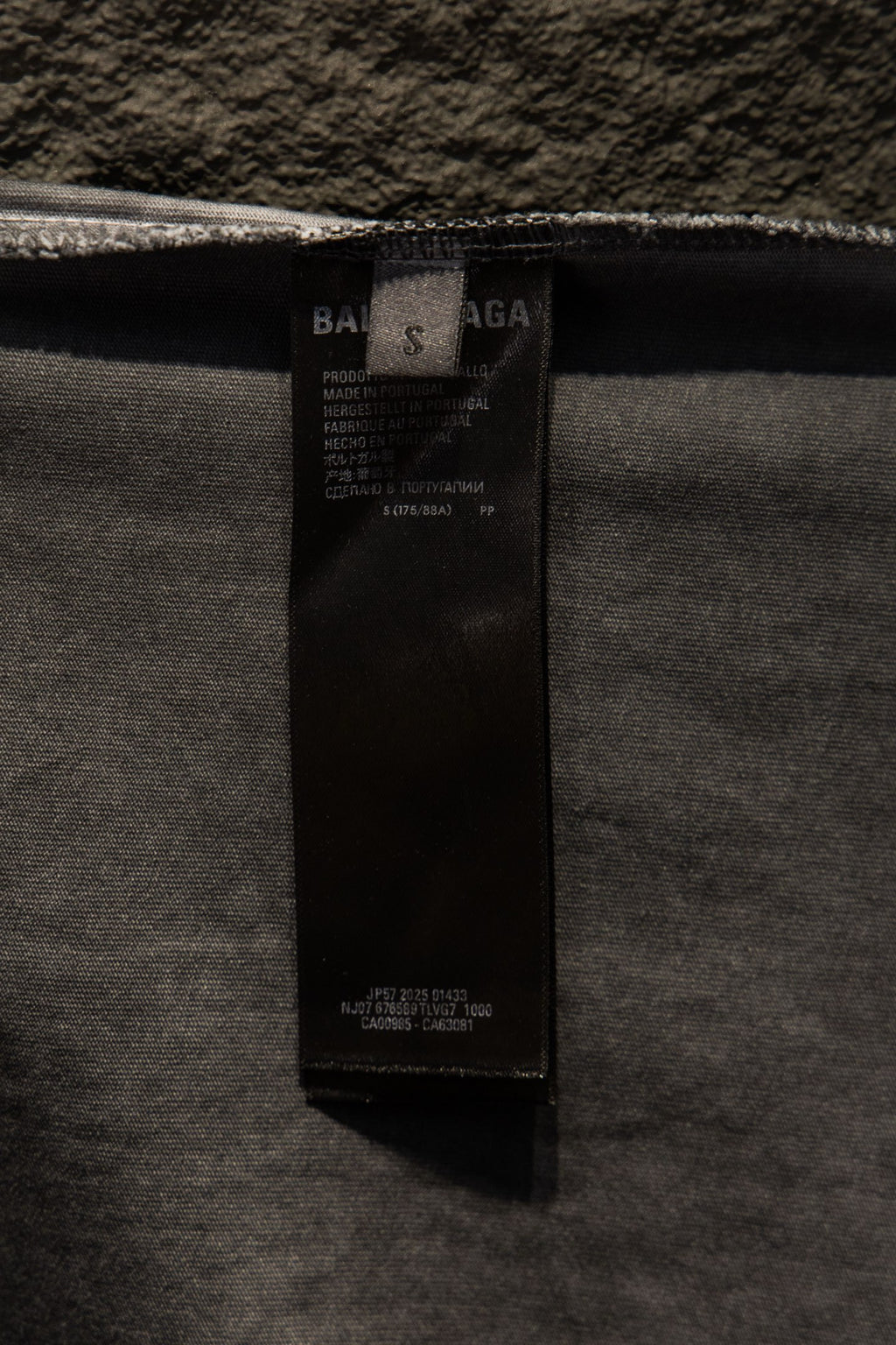 Black care label inside light gray T-shirt near neckline