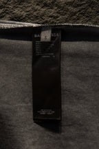 Black care label inside light gray T-shirt near neckline