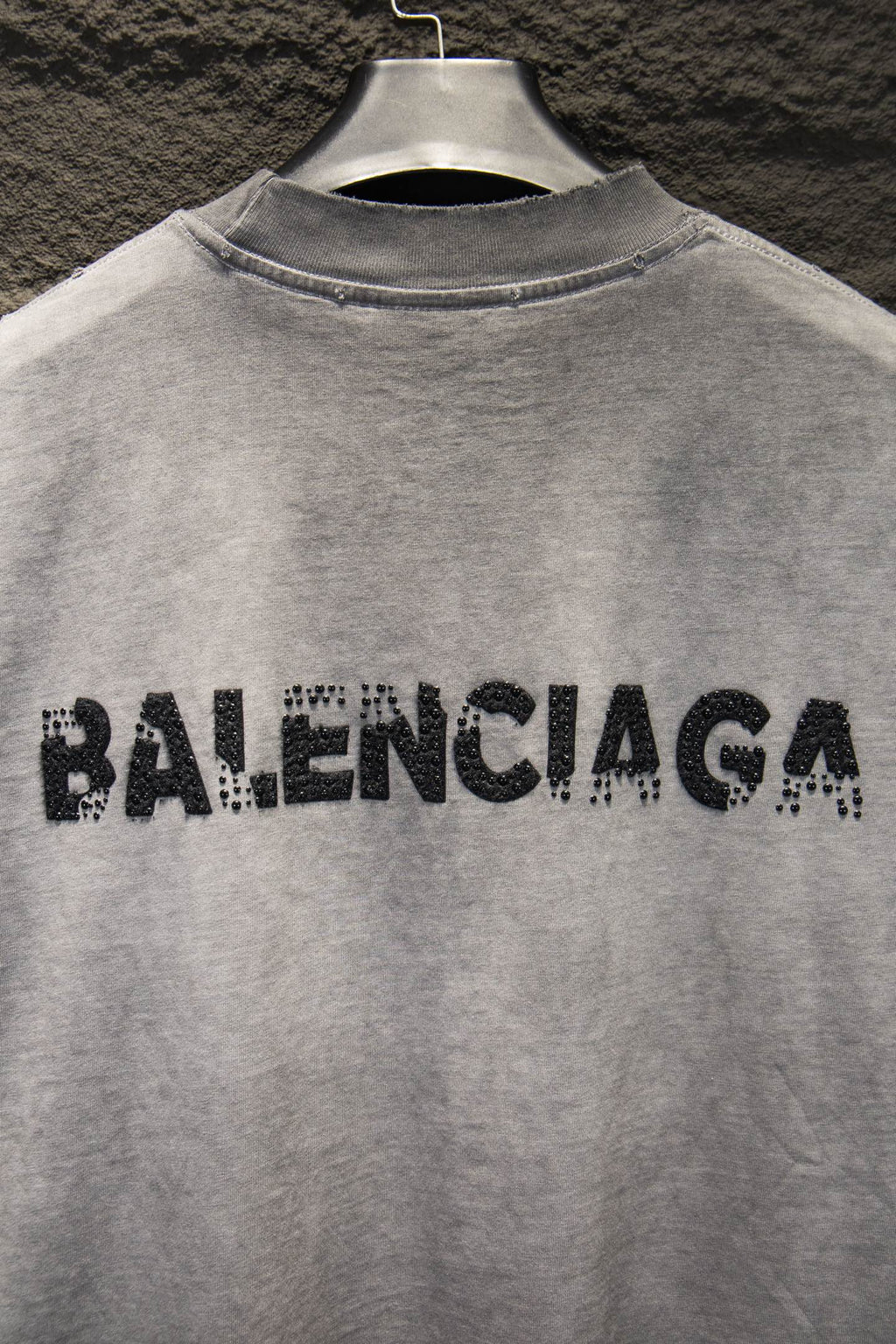 Light gray T-shirt with black BALENCIAGA rhinestone logo across upper back