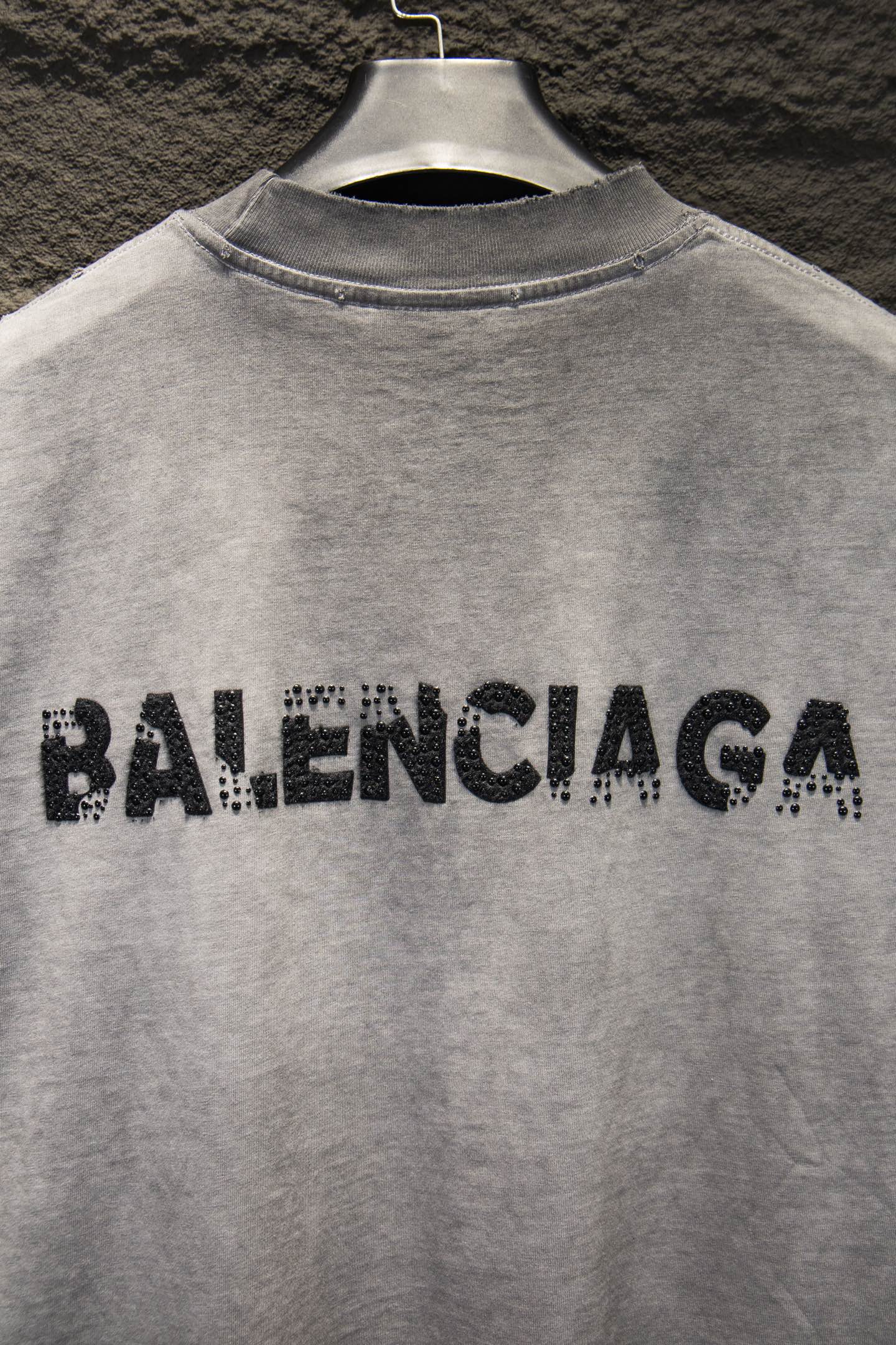 Light gray T-shirt with black BALENCIAGA rhinestone logo across upper back