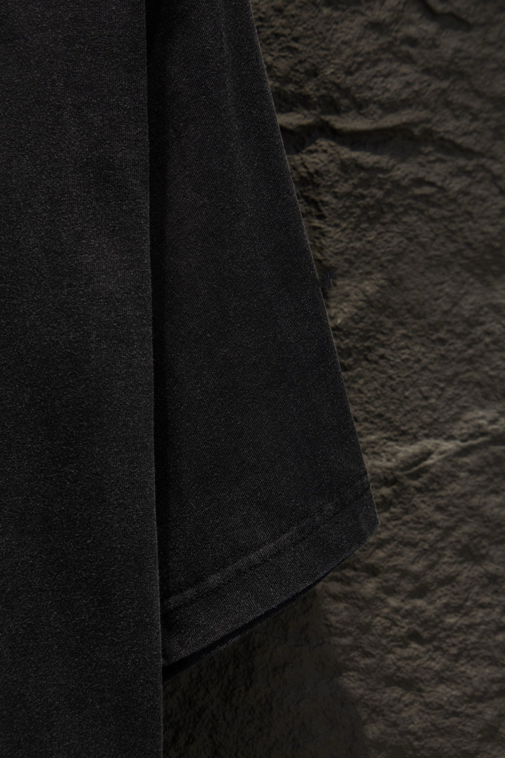 Balenciaga T-shirt sleeve edge close-up, dark gray fabric with seam