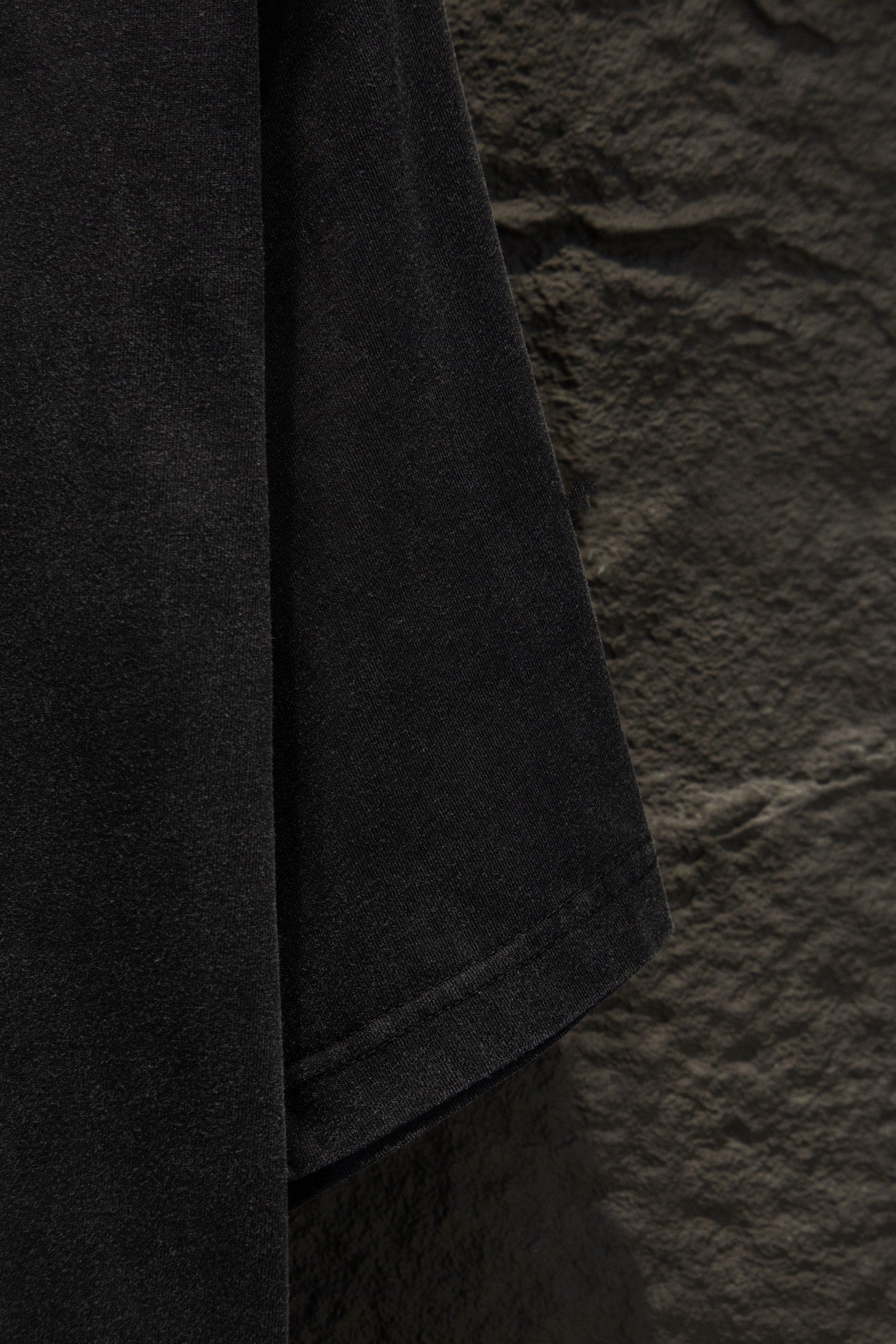 Balenciaga T-shirt sleeve edge close-up, dark gray fabric with seam
