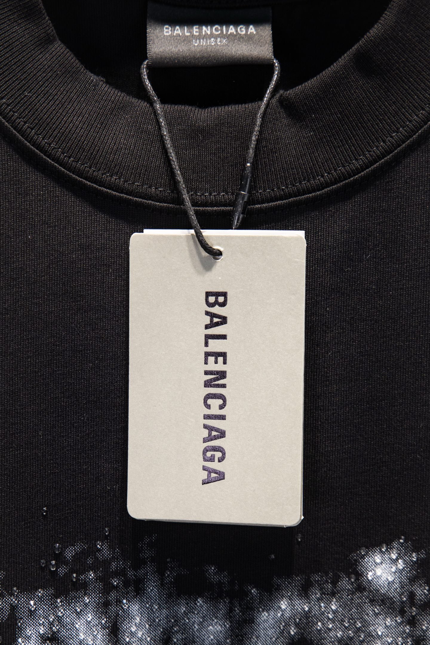 Black T-shirt neckline with hanging white tag and Balenciaga brand text