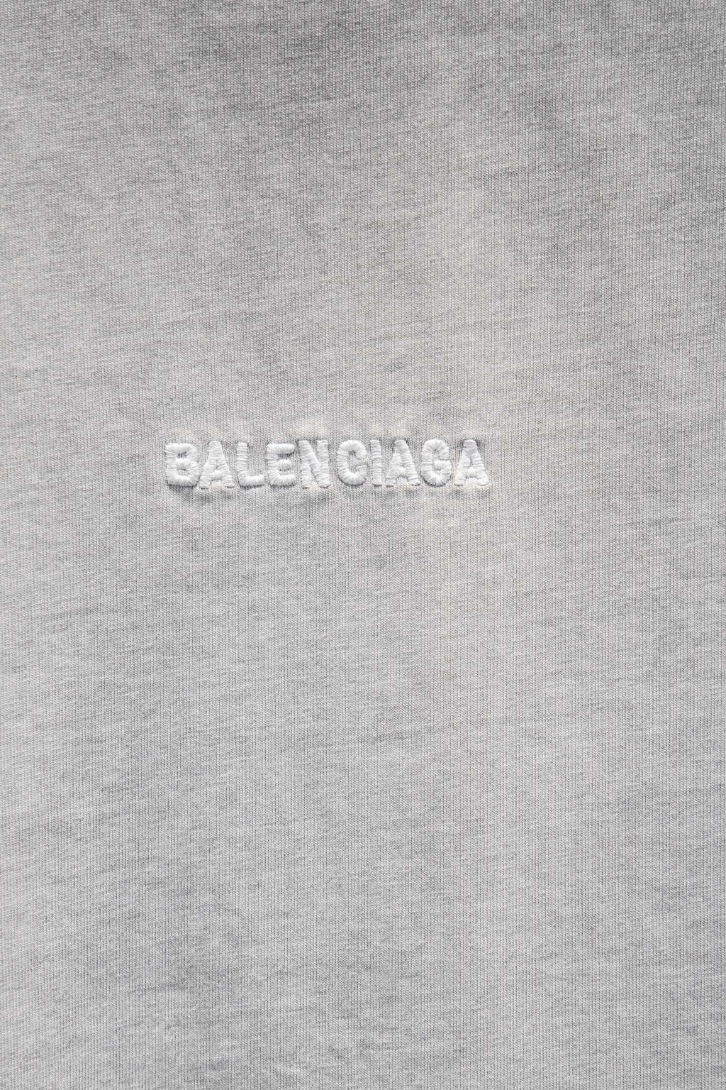 Balenciaga T-shirt fabric close-up with embossed 'BALENCIAGA' text.
