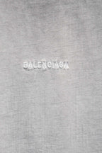 Balenciaga T-shirt fabric close-up with embossed 'BALENCIAGA' text.