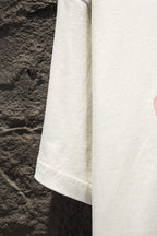 White T-shirt sleeve and side panel detail with visible hem stitching