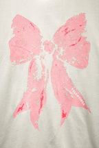 White T-shirt featuring a large pink bow graphic across the chest