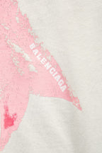White T-shirt detail showing pink bow graphic with partial “BALENCIAGA” text