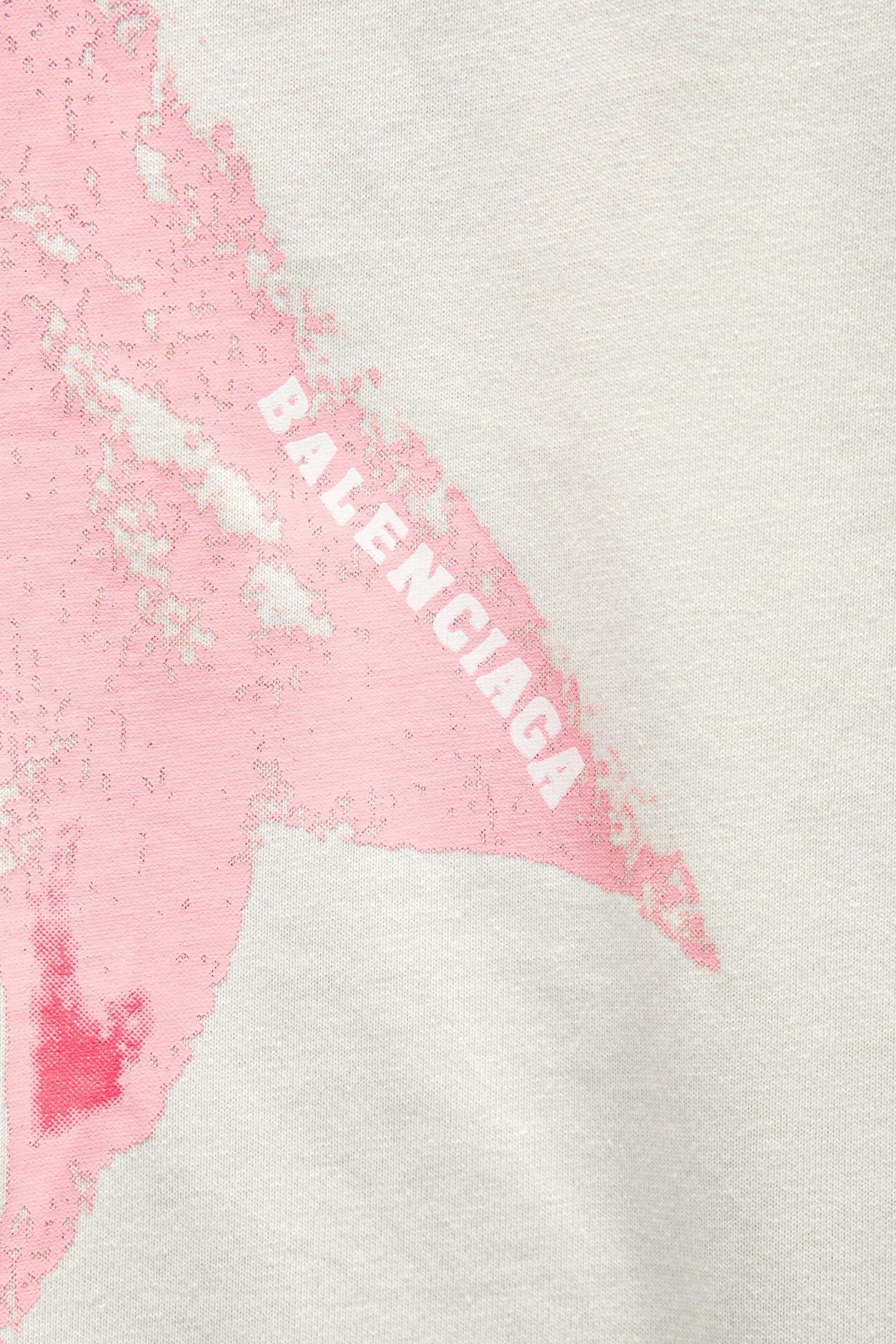 White T-shirt detail showing pink bow graphic with partial “BALENCIAGA” text
