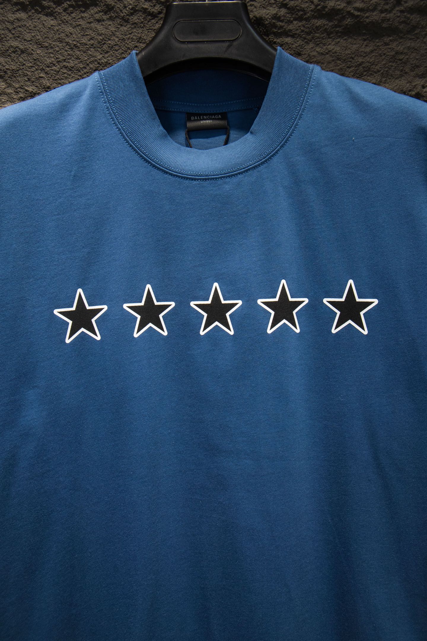 Blue T-shirt with five outlined star graphics across the chest