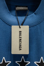 Blue T-shirt neck close-up with hanging Balenciaga tag and star graphics