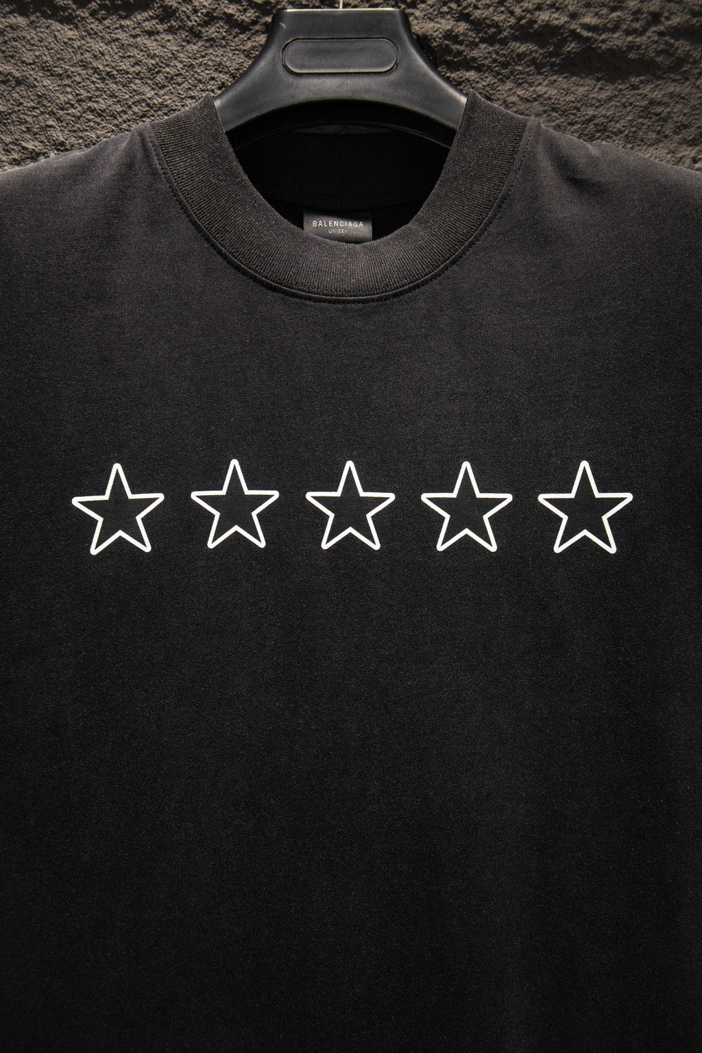 Black crewneck T-shirt with five white star prints across the chest