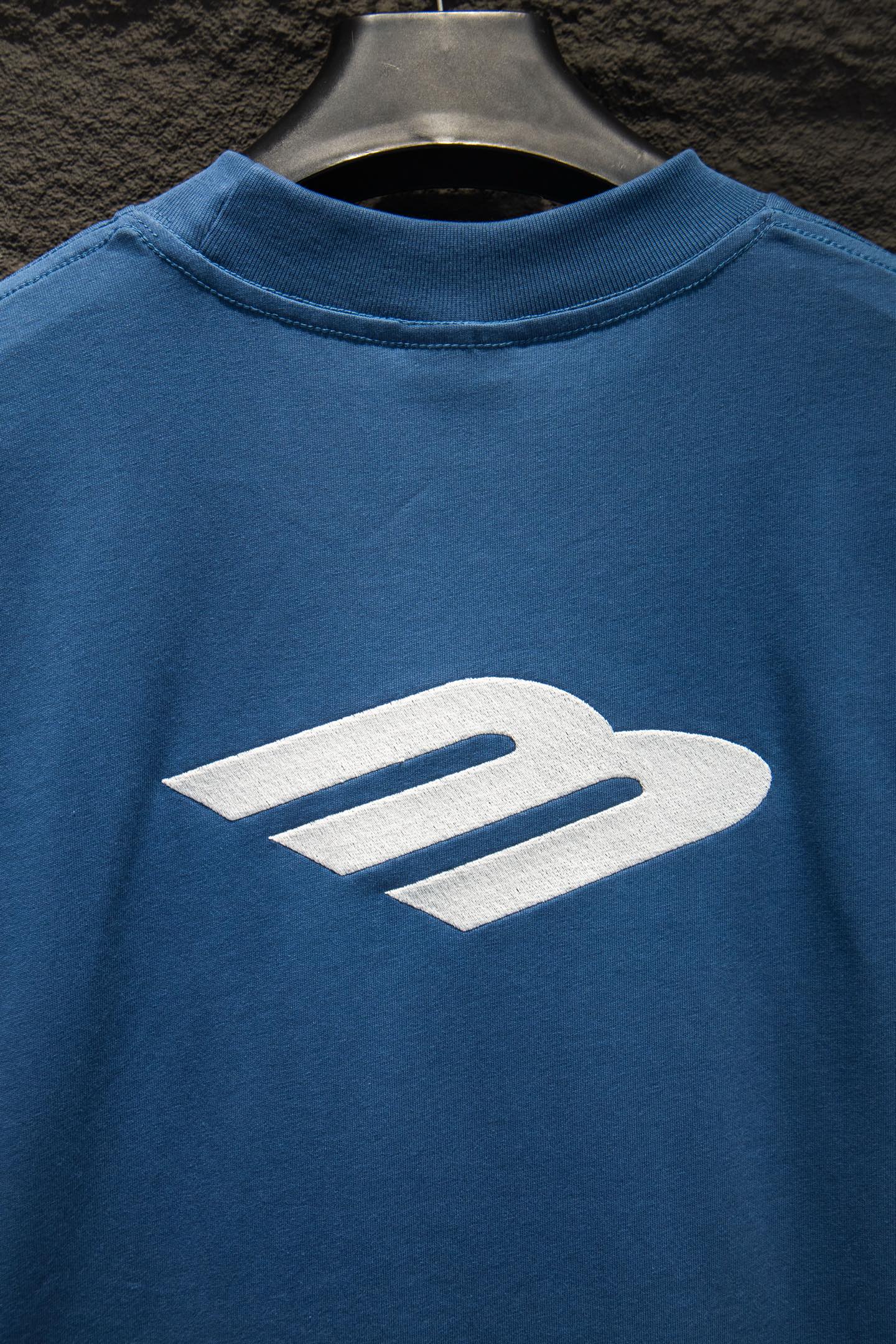 Blue T-shirt with large white logo print on the chest