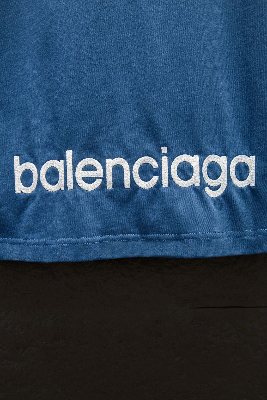 Blue T-shirt with 'balenciaga' logo text near the hem
