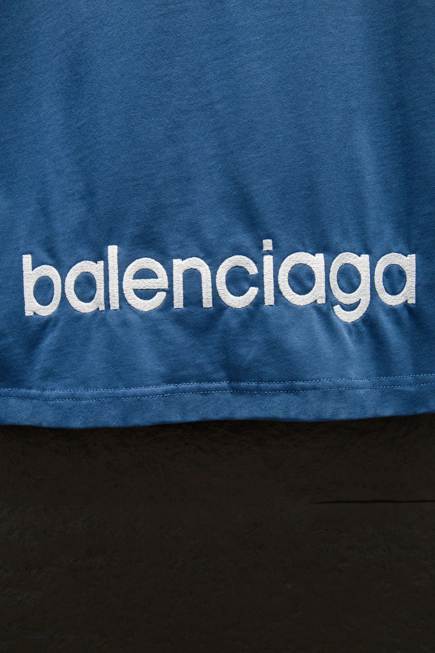 Blue T-shirt with 'balenciaga' logo text near the hem