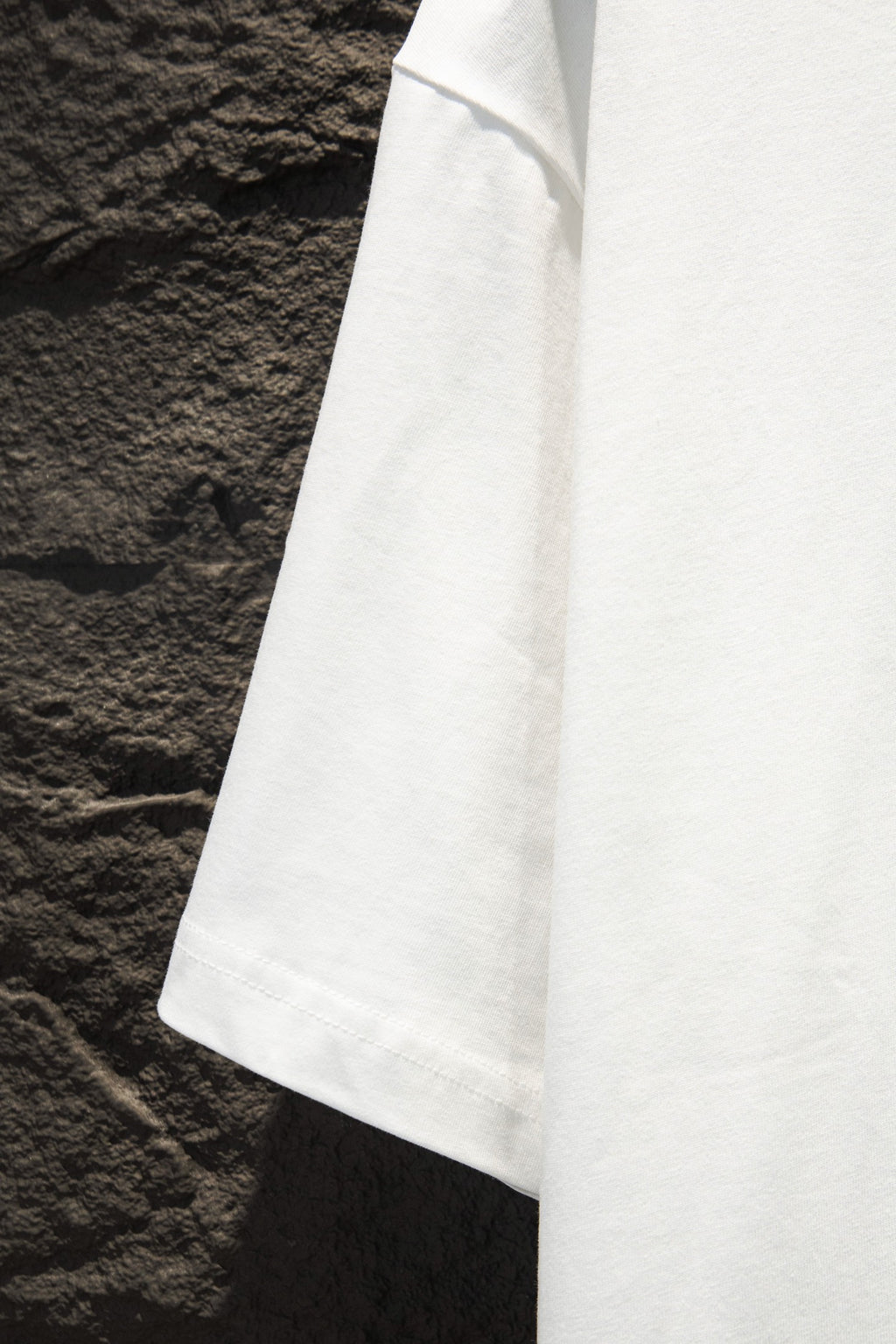 White short-sleeve T-shirt sleeve and side seam detail.