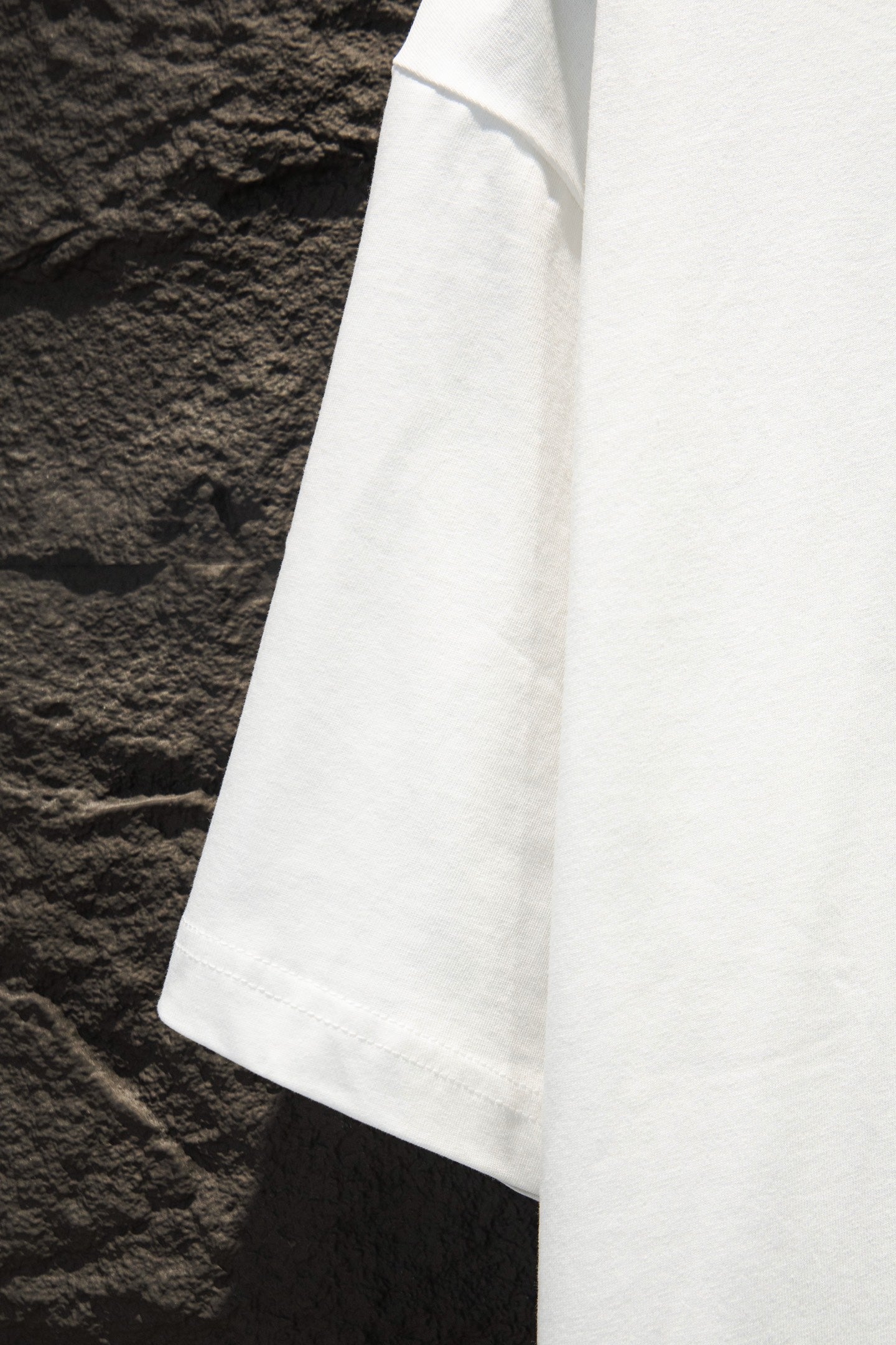White short-sleeve T-shirt sleeve and side seam detail.