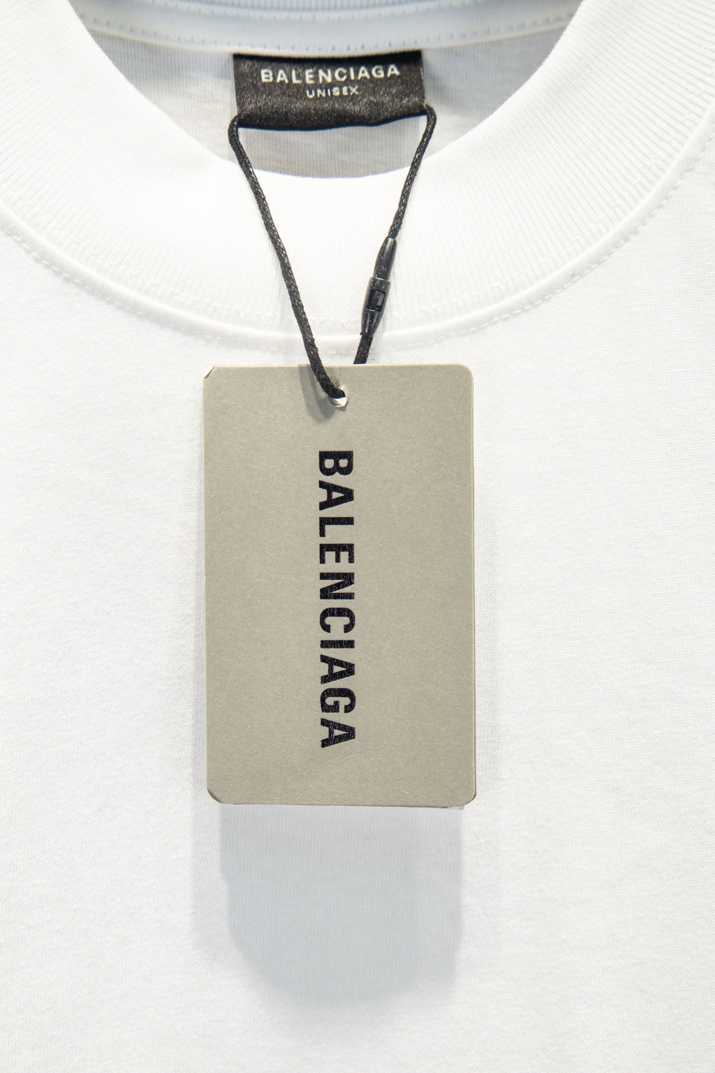 White T-shirt with Balenciaga inner neck label and attached product tag.