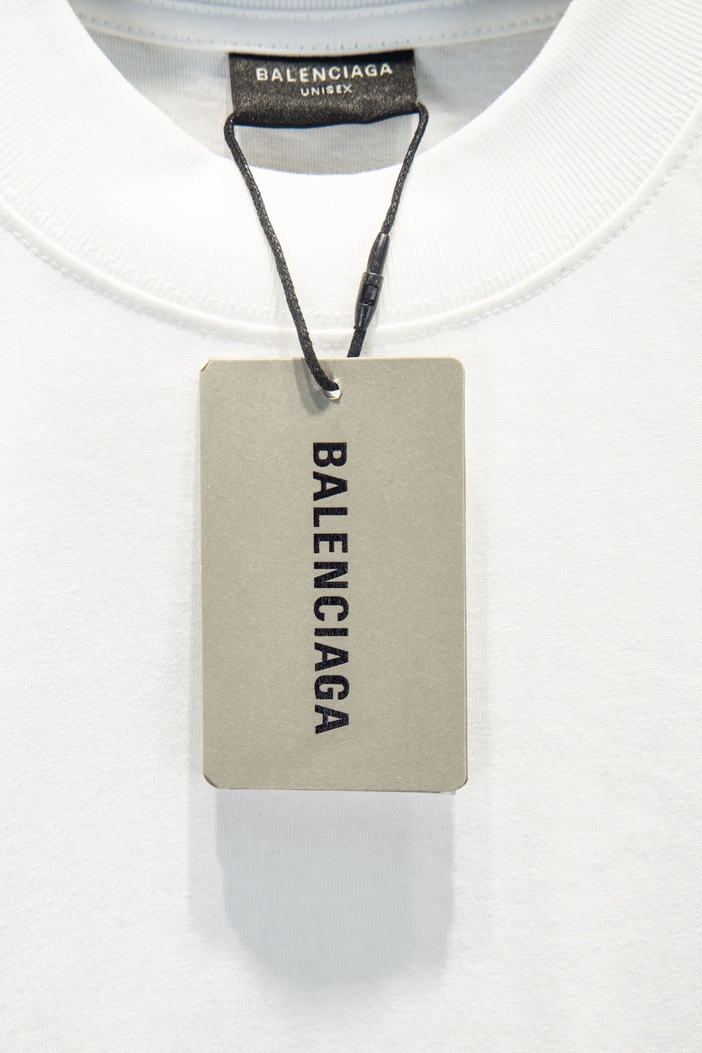 White T-shirt with Balenciaga inner neck label and attached product tag.