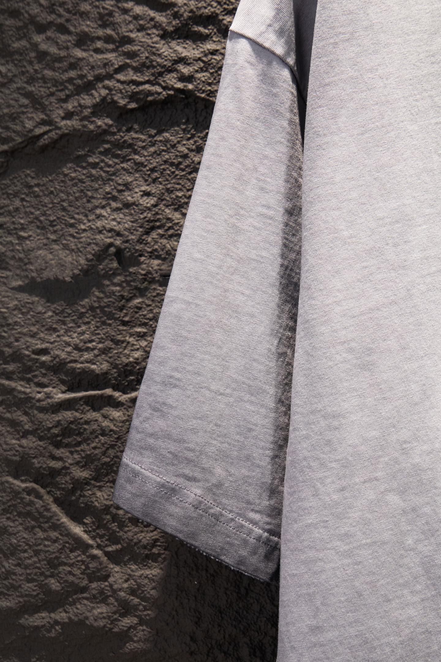 Light gray T-shirt side view with short sleeves and straight hem