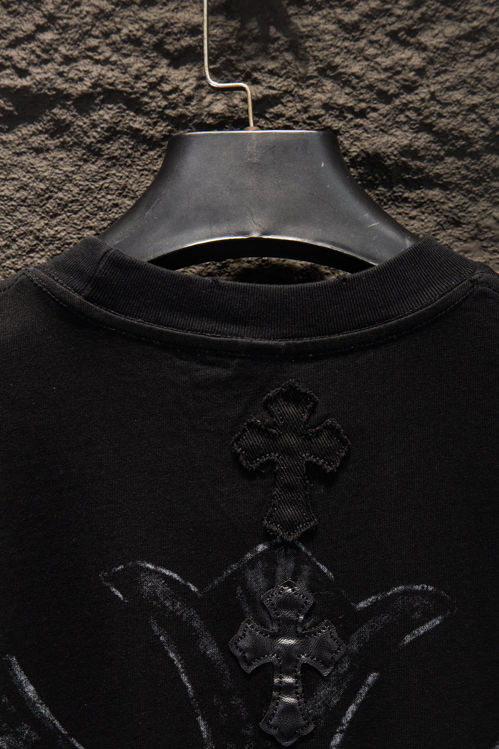 Black T-shirt with large front cross emblem near chest