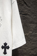 White short-sleeve T-shirt sleeve with small black cross patch