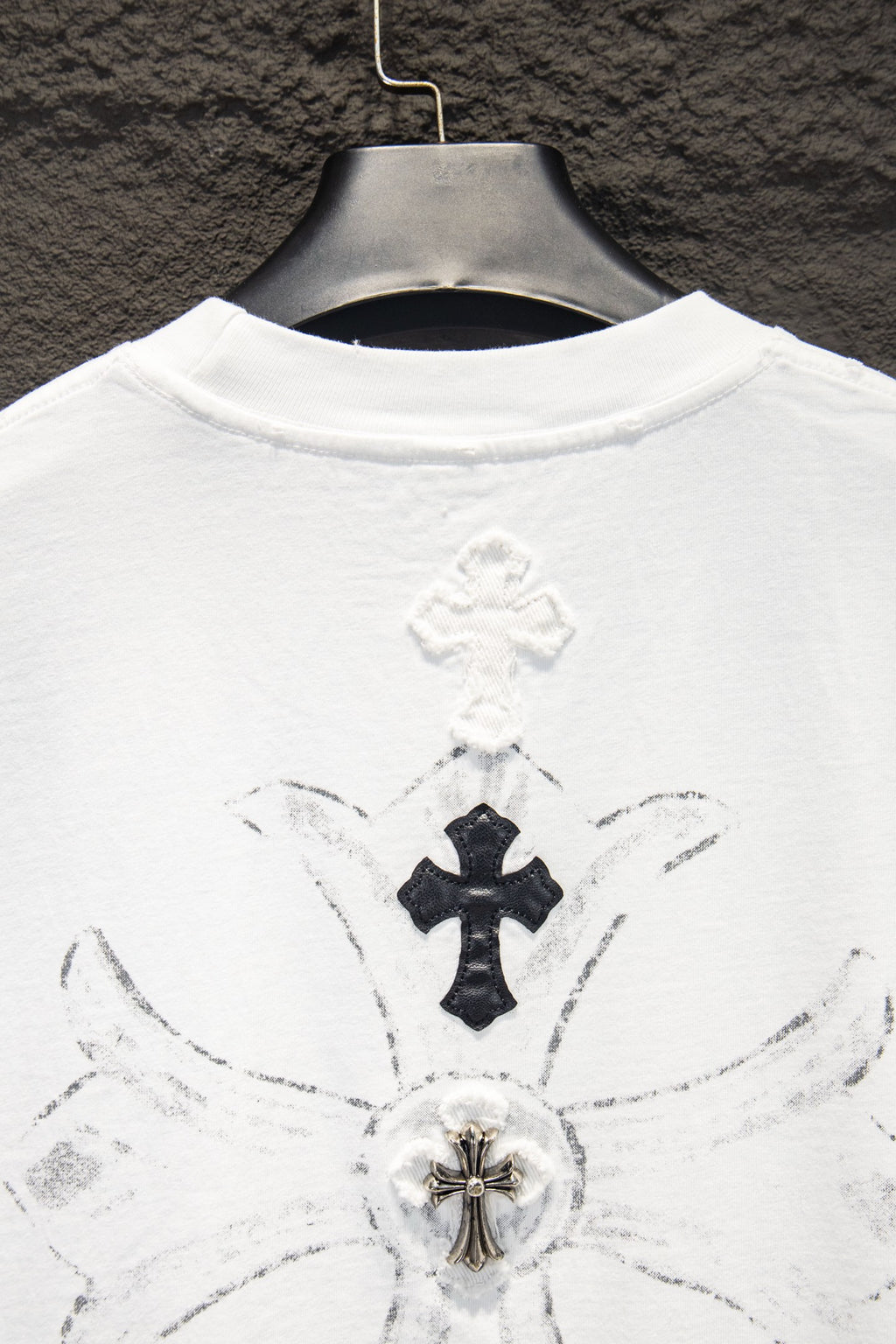 White T-shirt back with large cross emblem and radiating connector lines