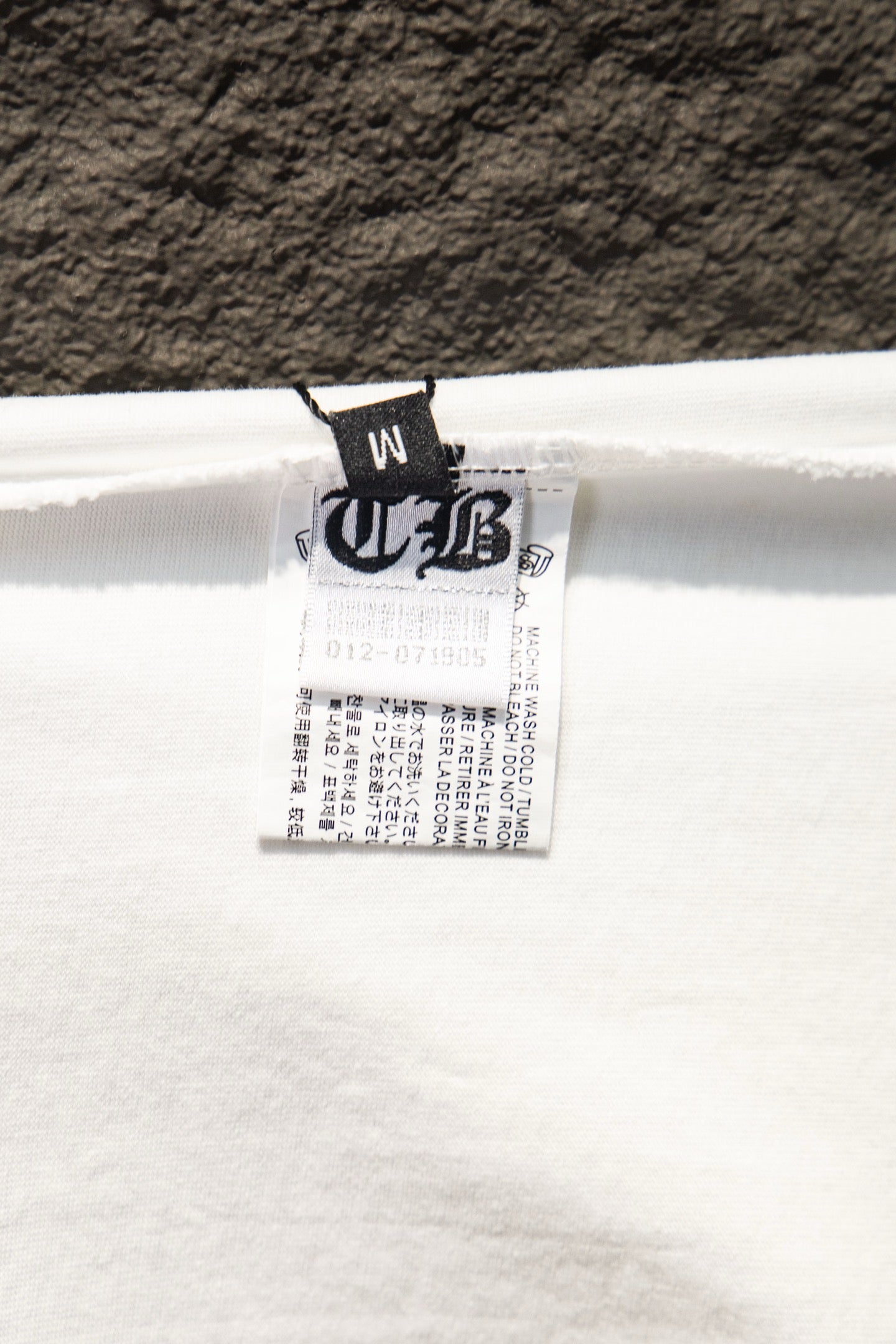 White T-shirt care label inside the neckline with printed text