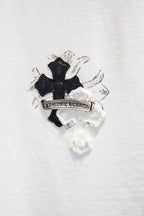 Black cross patch with ornate label graphic on white T-shirt front