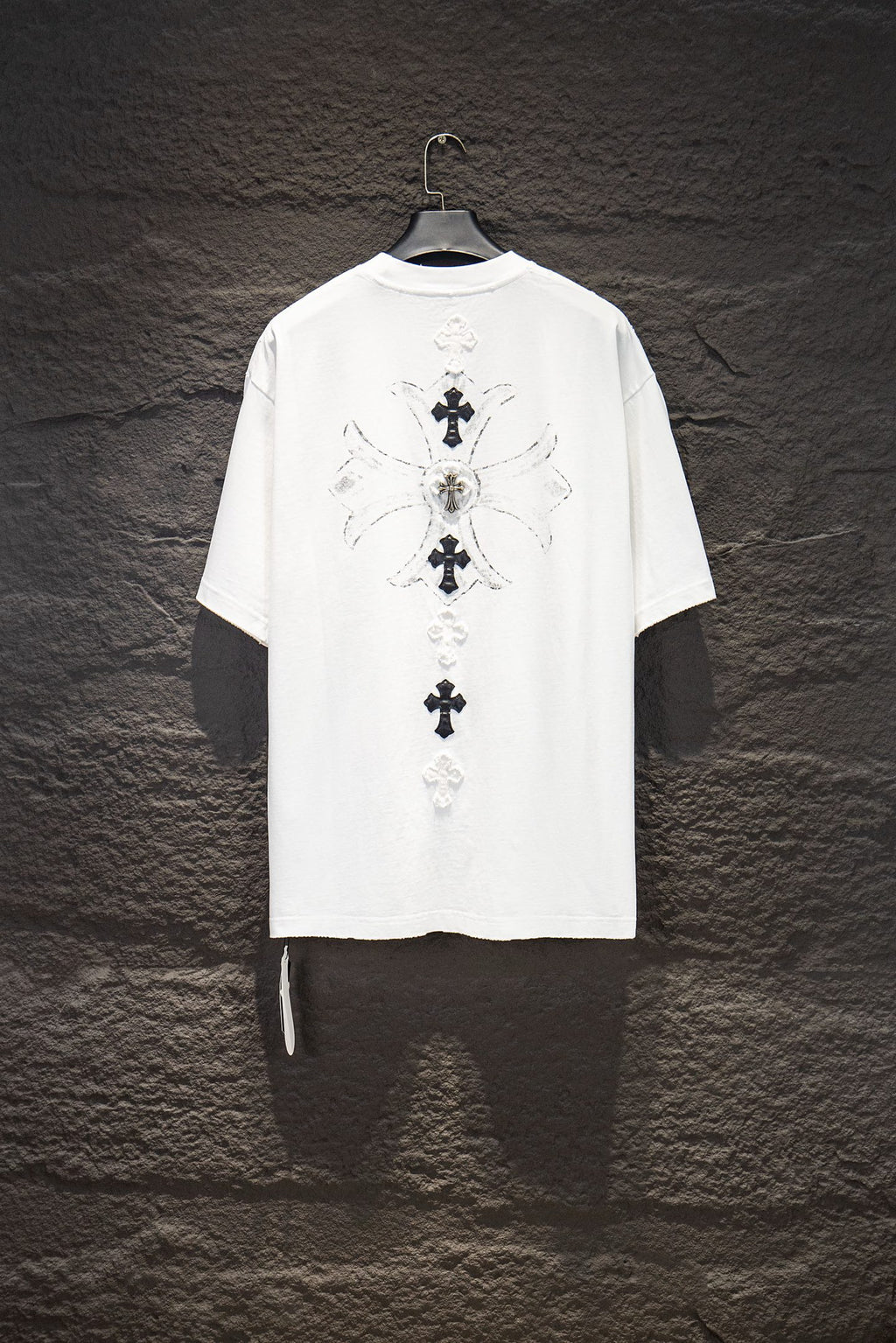 White short-sleeve graphic T-shirt with large back cross design and ribbon detail