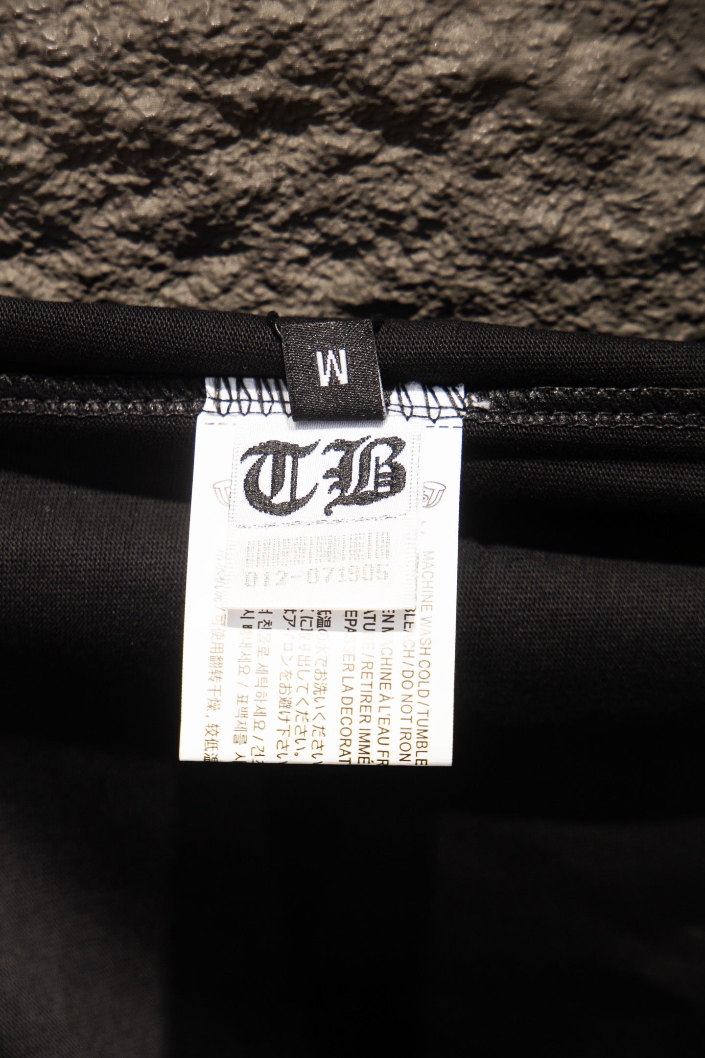 Black T-shirt with size and care label on inner neck seam
