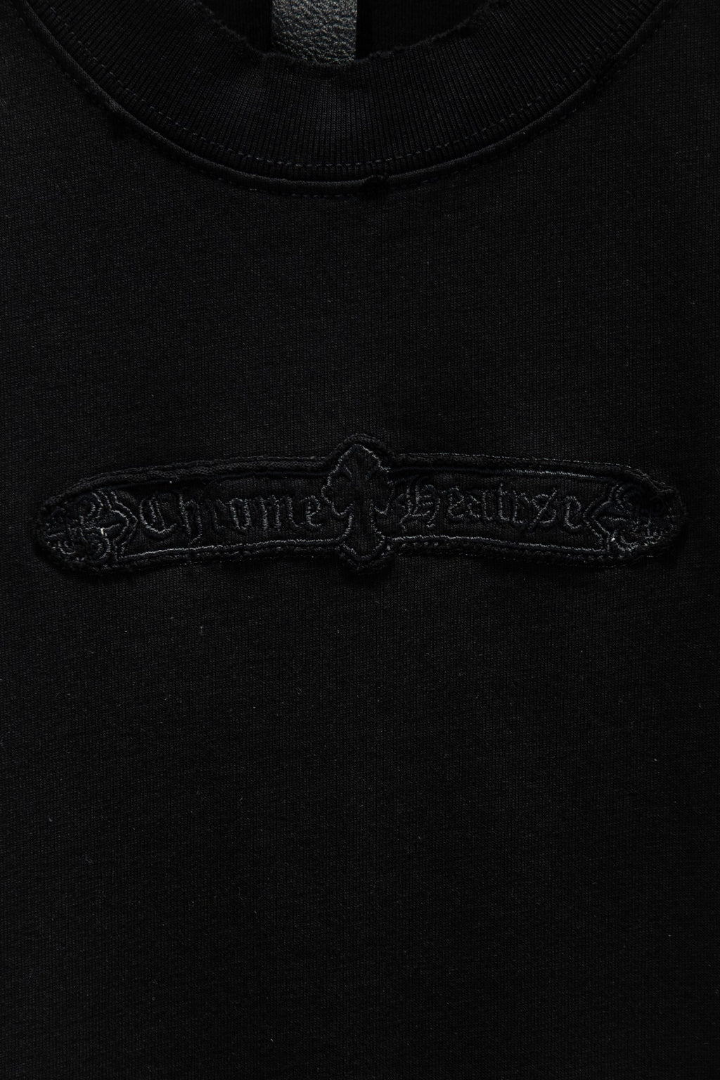 Black T-shirt with detailed embroidered logo across upper chest