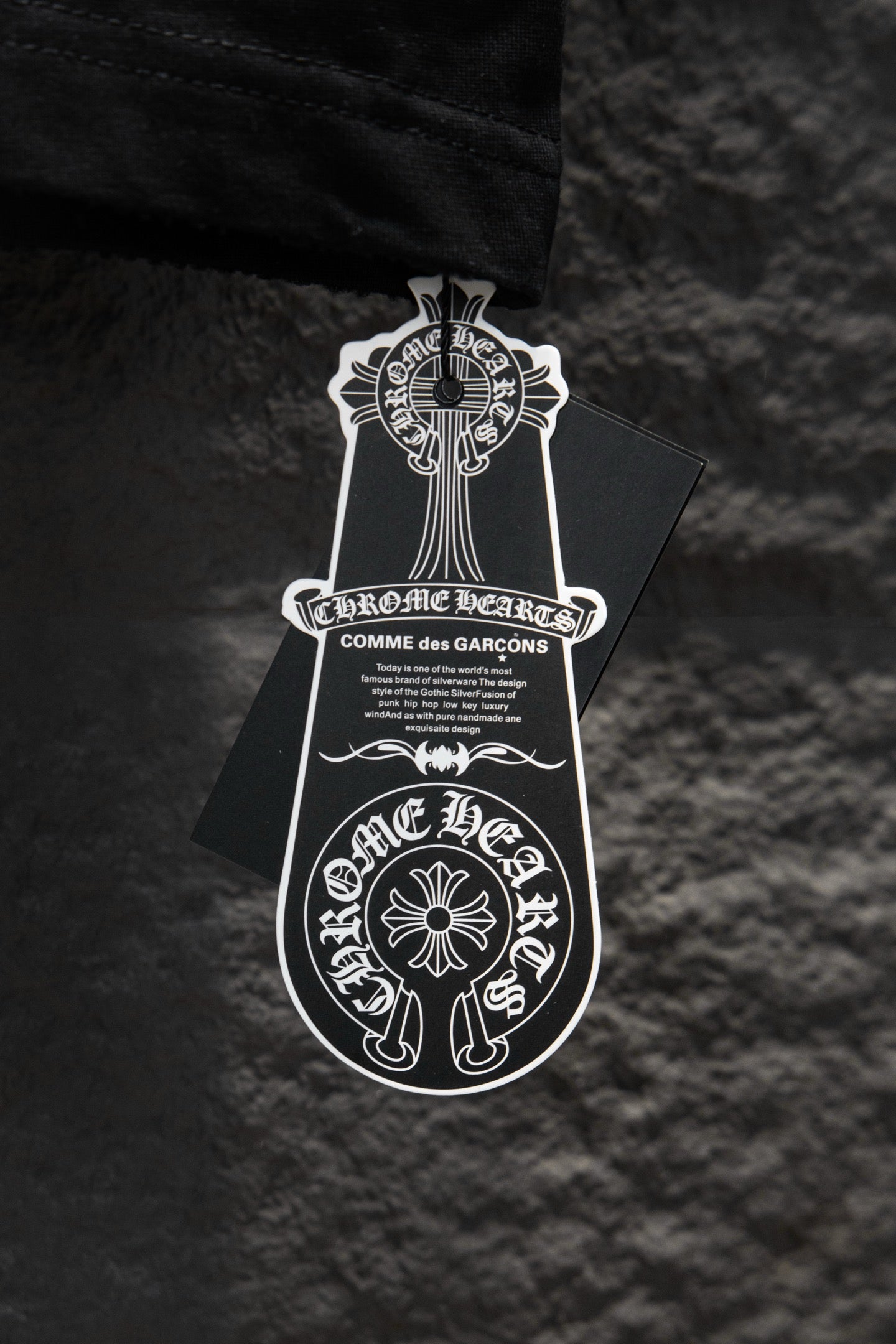 Black T-shirt with attached white emblem hang tag