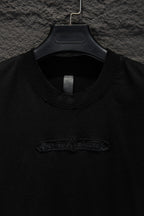 Black crewneck T-shirt with embroidered logo detail near the chest